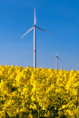 Wind energy symbolized by blurred windmill turbines with blue sky on a sunny day in Germany on a...