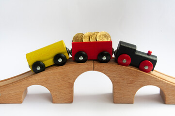 Wooden toy train with gold coins.Business concept