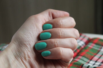 Closeup hands of the woman fingers green manicure nails