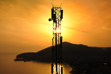 Amazing closeup sunset drone view of silhouette of cell tower. Wireless connection. Spectacular...