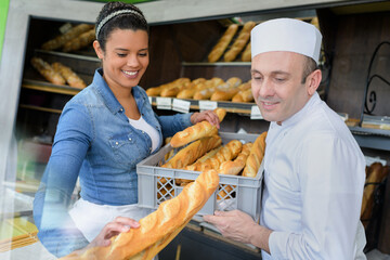 man and woman in uniform bakers working in a bakery