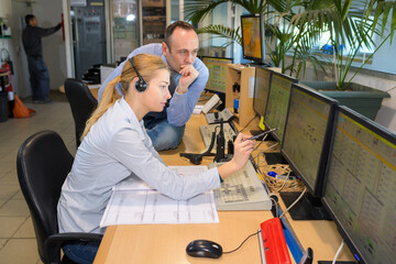 workers assessing information in computer control station