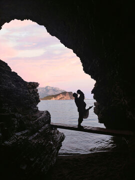 Silhouette of couple in a cave in front of a beautiful seascape on Mogren beach