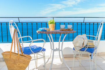 white wrought iron table and chairs on a terrace with beautiful views of the sea to enjoy your vacation.