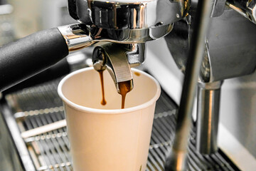 Professional coffee making machine pouring a take out drink