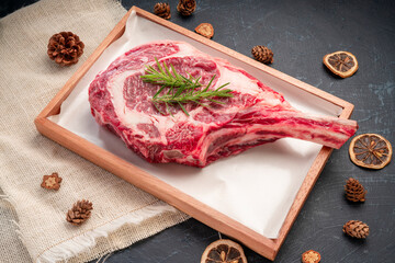 Fresh Tomahawk beef steak with rosemary on wooden plate, Tomahawk beef steak on black wooden...