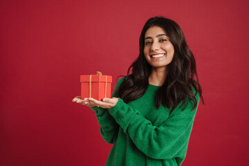 East asian woman smiling while posing with gift box
