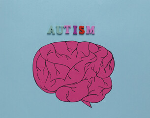 Paper cut head with brain and inscription autism on blue background. Psychological illness