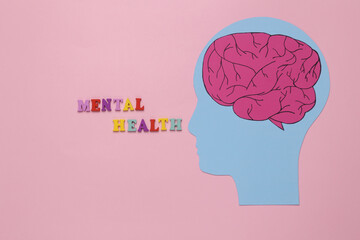 Paper cut head with brain and inscription mental health on pink background