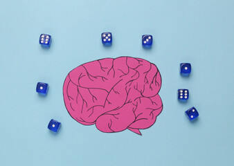 Paper cut brain with dice on blue background. Luck and intelligence concept