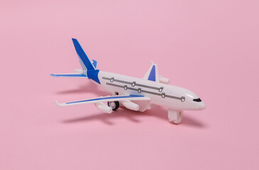 Travel, tourism or voyage concept. Model of a passenger plane on pink background