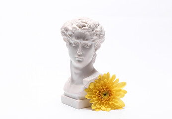 Aesthetic still life, David bust with yellow flower isolated on a white background. Romantic, love concept