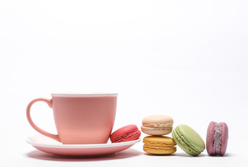 Ceramic tea cup with macaroons isolated on white background