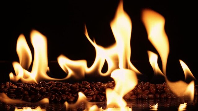 Braune Kaffeebohnen mit Feuerflammen auf schwarzen Hintergrund und Spiegelung