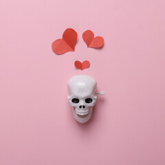 Skeleton skull with hearts on a pink background. Valentine's day or halloween celebration concept....