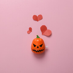 Pumpkin jack head with hearts on a pink background. Valentine's day or halloween celebration concept. Minmal layout