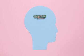 Paper cut human head with a microchip instead of a brain on a blue background. Cybernetization, AI...