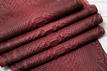 red terracotta dyed genuine natural python leather on the wooden table