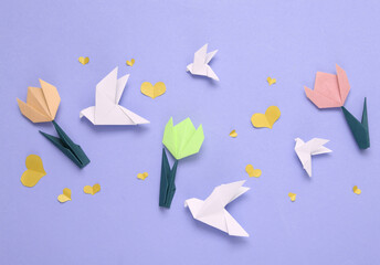 Spring festive composition of origami tulip flowers, doves, hearts on a purple background