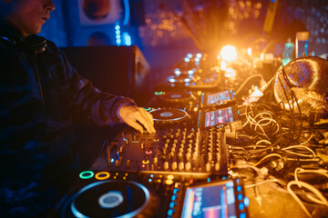 Close up view of a dj's hands playing the mixer while performing in a music festival. High quality photo