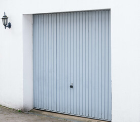 Obraz na płótnie Canvas Gray metal garage door and white brickwork