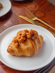 Croissant with caramel hazelnut in the white plate.
