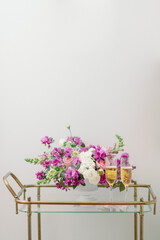 purple flower centerpiece on bar cart with champagne flutes