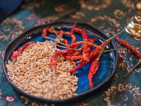 Rice Grains And Dried Chilies On The Dark Blue Plate.