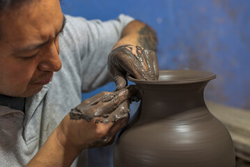 Latin artisan working on a vase of clay for the talavera process