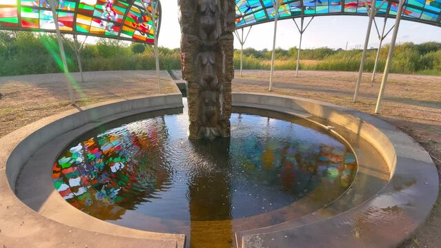 Granite pillar ornamented with female bodies over which water constantly flows down and four pavilions with roofs of colored glass - Lovers Island K&aelig;rligheds&oslash;en. Copenhagen, Denmark