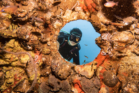 diver exploring the wreck of the HTMS Sattakut in Thailand