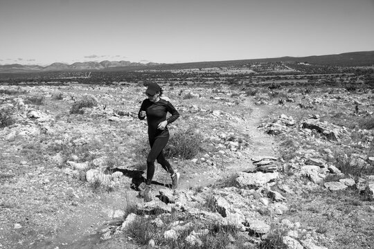 Woman Wearing Black Trail Running On A Rocky Terrain