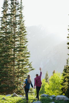 Couple holding hands and walking on rocks in Utah Big Cottonwood