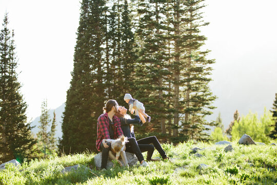 Family looking at baby sitting on rocks in Big Cottonwood Canyon