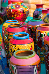 Beautiful painted colorful terracotta pots, works of handicraft, for sale during Handicraft Fair in Kolkata. Vertical image.