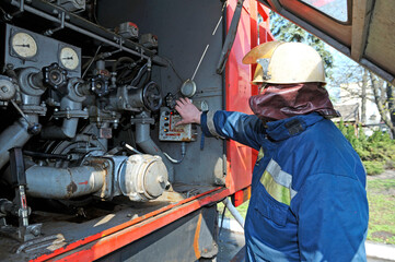 Fireman switching the water pump engine on control panel