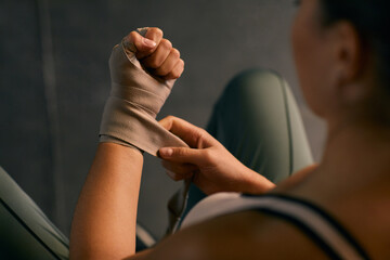 From above horizontal shot of professional female boxing using wristwraps for protecting her hands