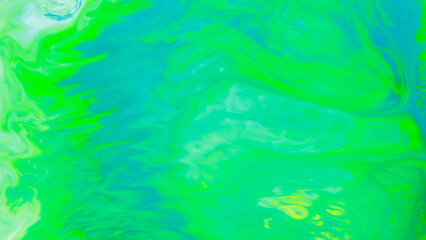 Fototapeta na wymiar Fluid art background in green color. Green-turquoise stains on liquid. Creative background with blurred paints. Background for an eco-friendly concept