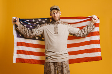 European military man wearing uniform posing with american flag