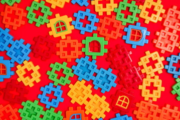 Bright background texture from multi-colored plastic fragments of a childrens puzzle constructor