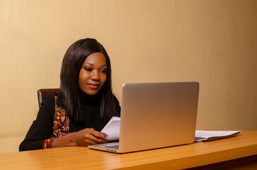 beautiful lady in the office smiling as she goes through the file on her hand