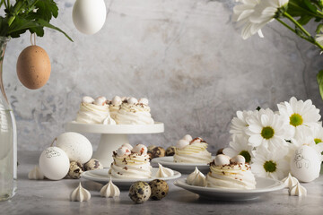 Obraz na płótnie Canvas Array of meringue creations with quail eggs, paired with fresh white daisies and small meringue pieces.
