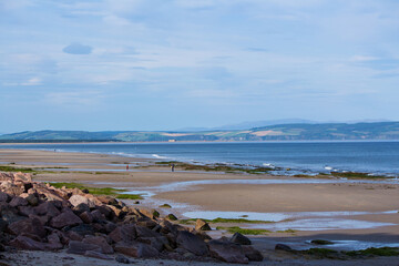 Fototapeta na wymiar Promeneurs sur la plage de Nairn à marée basse au nord de l'Écosse au Royaume-Uni