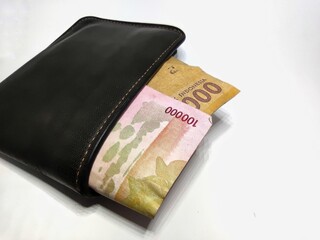 Money in black leather wallet isolated on white background