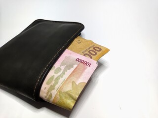 Money in black leather wallet isolated on white background