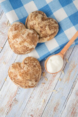 Beautiful heart-shaped gingerbread cookies are arranged with sour cream. Delicious cookies with spikelets