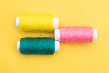 yarn or spool thread over on yellow background
