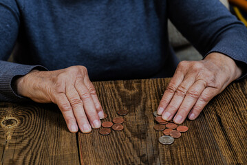 Hands of an elderly woman counting coins close-up.