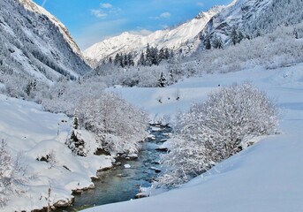 Verschneite Gebirgslandschaft mit Bach