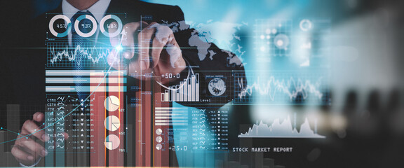 Businessman working with modern computer analyzing sales data and economic growth graph chart,...